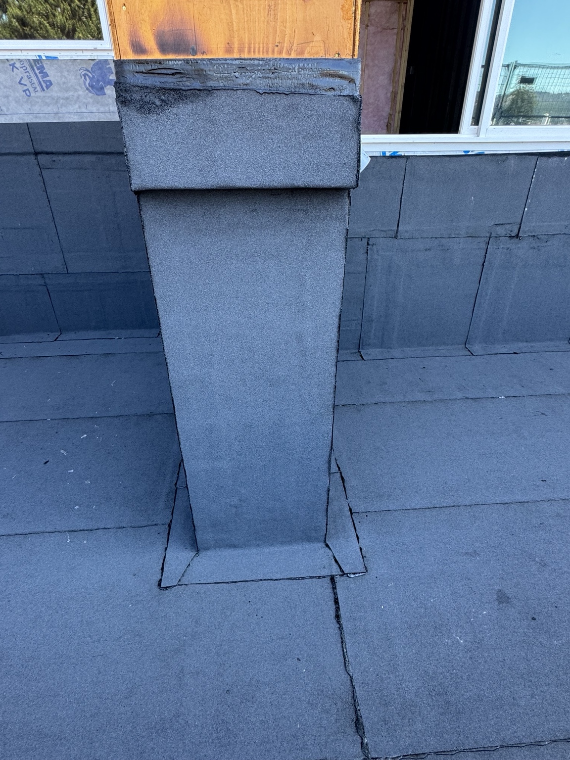Close view of a membrane-clad curb with folded corner transitions on a membrane surface